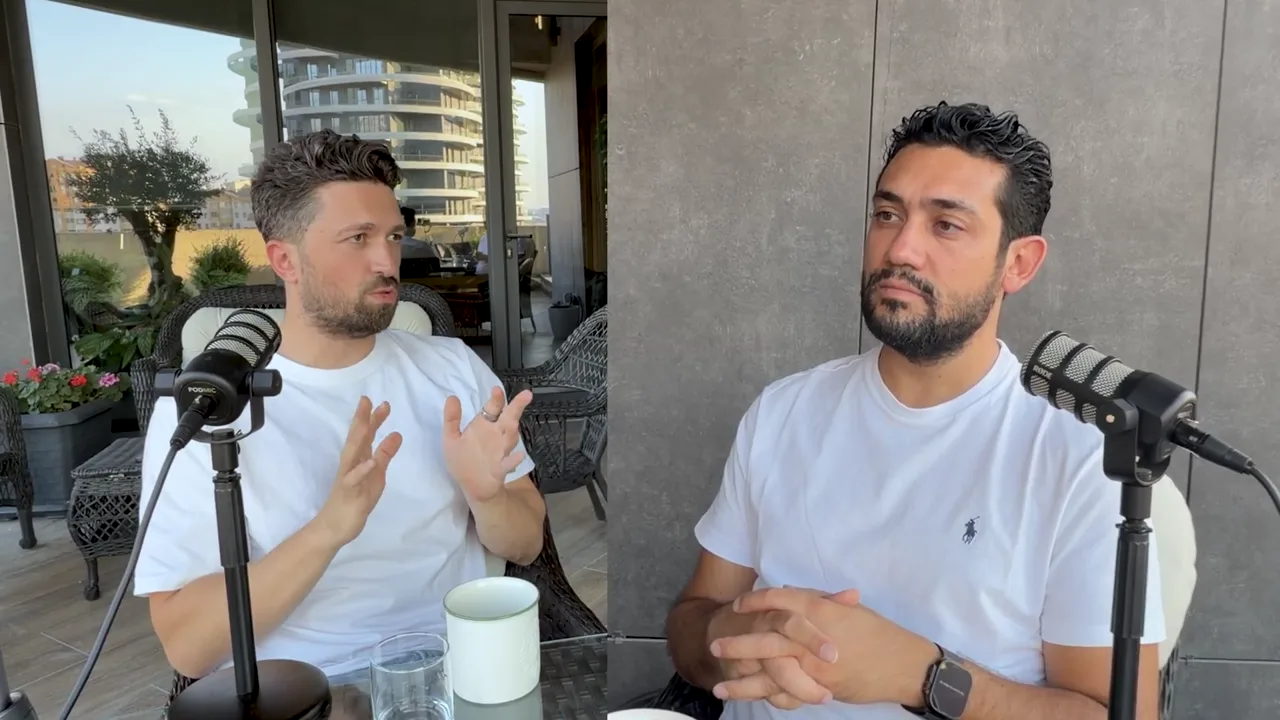 Emre Elbeyoglu yapay zekâ otomasyonlarının neden tutmadığını anlatırken el hareketi yapıyor, Evren Bayraktar dinliyor