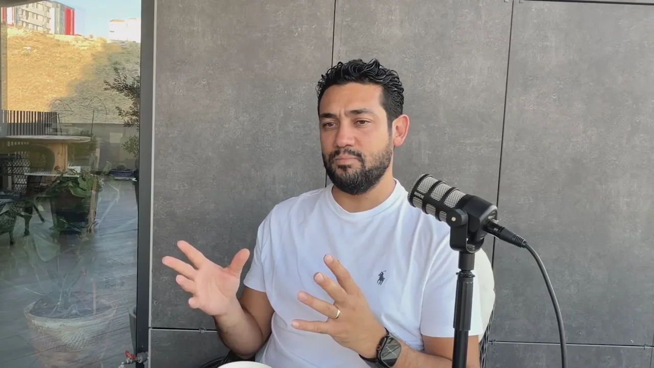 Evren Bayraktar gesturing at a podcast microphone while explaining why Jotform avoids sharp traffic spikes and drops