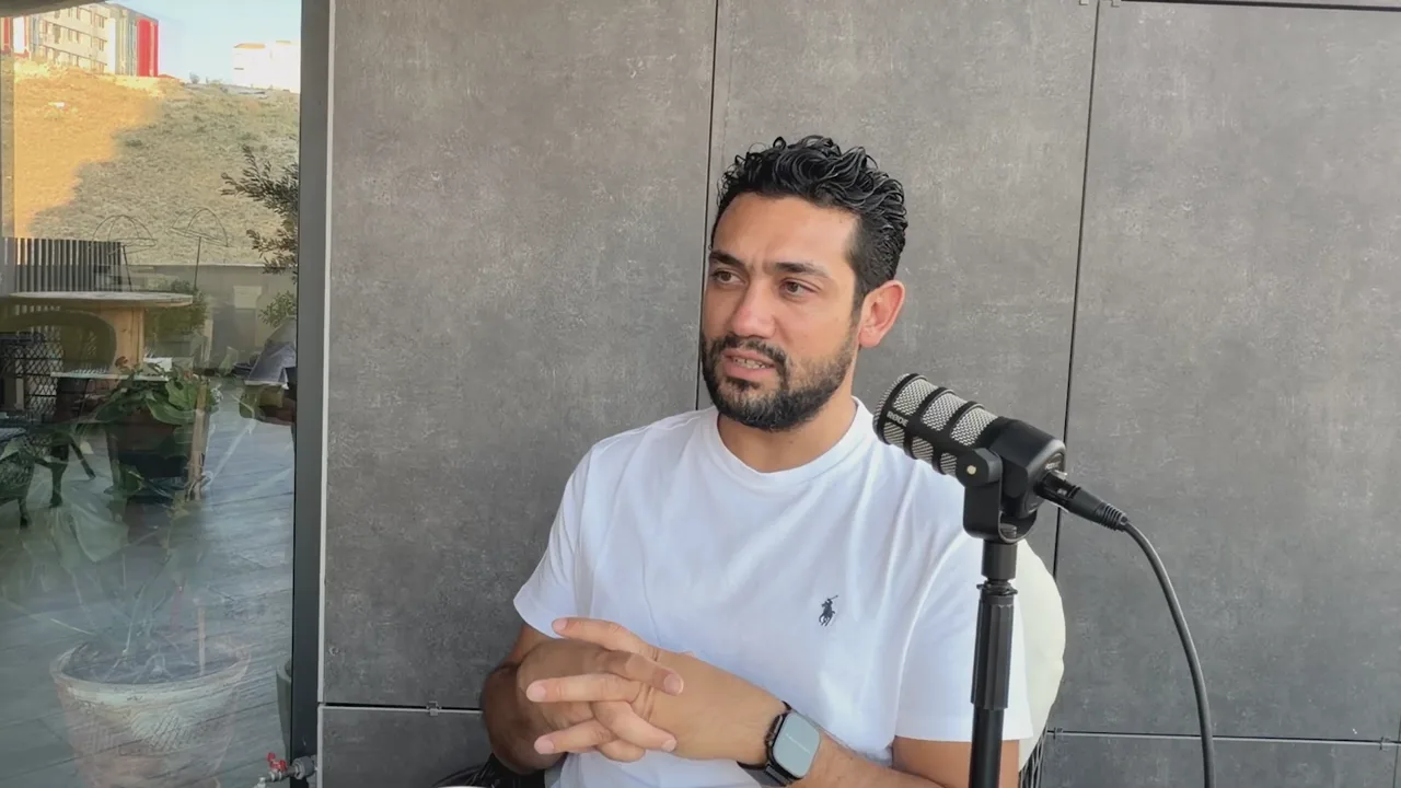 Evren Bayraktar at a podcast microphone sharing that 500 domains a day add a Jotform website widget